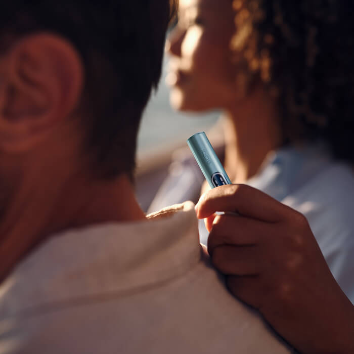 Man and woman enjoying the sunset with IQOS