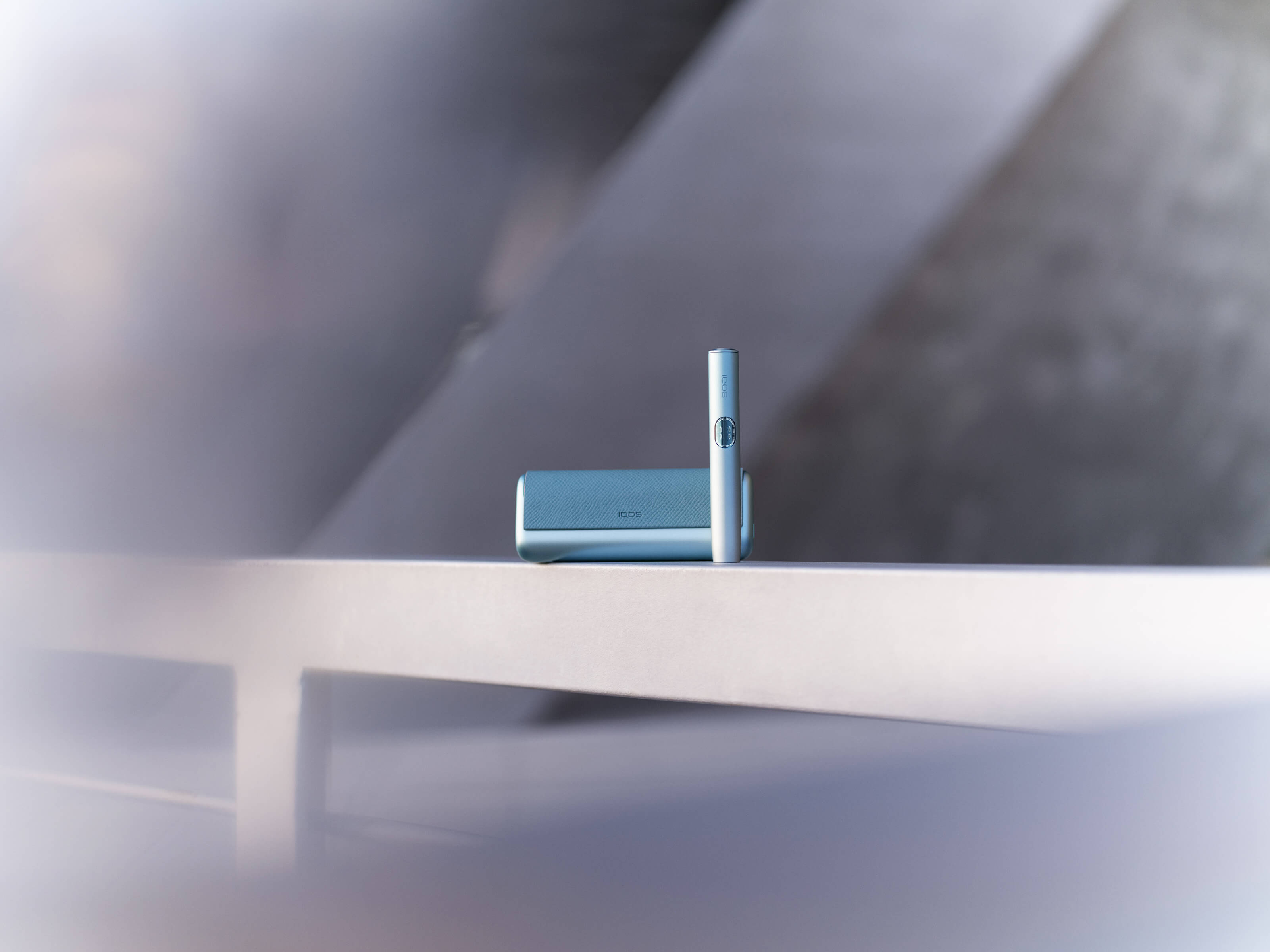 A moss green IQOS ILUMA Holder and Pocket Charger.