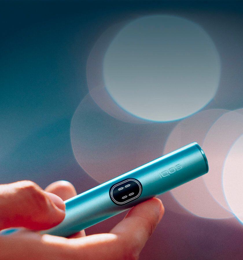 An IQOS ILUMA Holder in a person's hand.