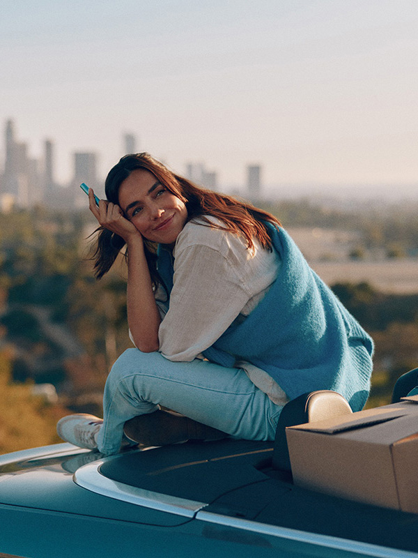 A woman sitting on a car