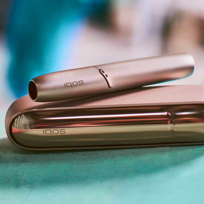 Couple embracing with IQOS 3 DUO holder and charger in his hand