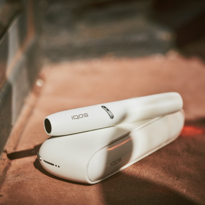 Woman on the street using an IQOS holder