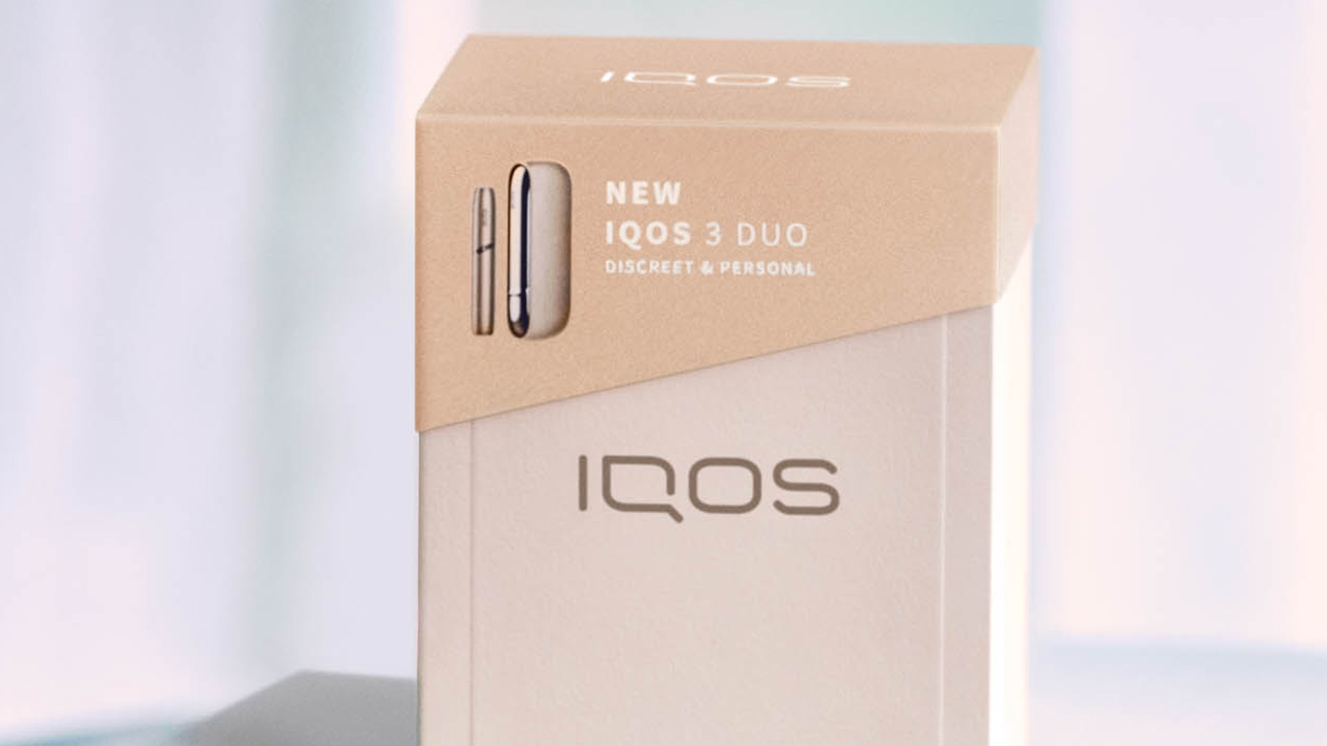 Blond woman opening her gold IQOS device