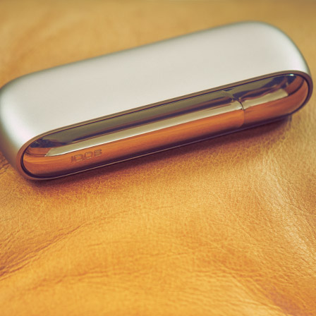 An IQOS device next to a bowl of popcorn.