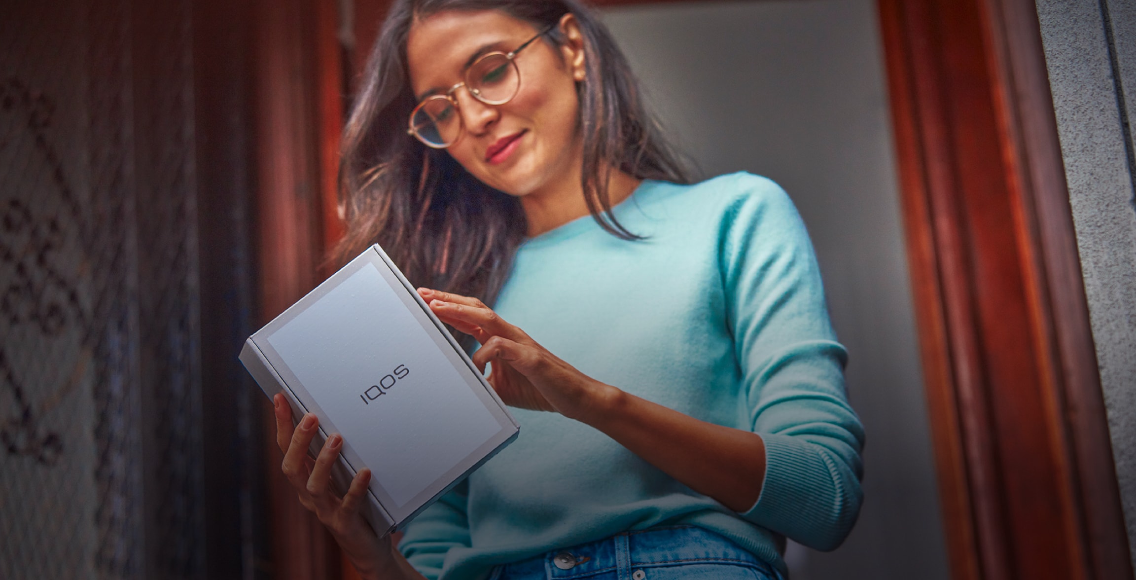 A woman with an IQOS box.