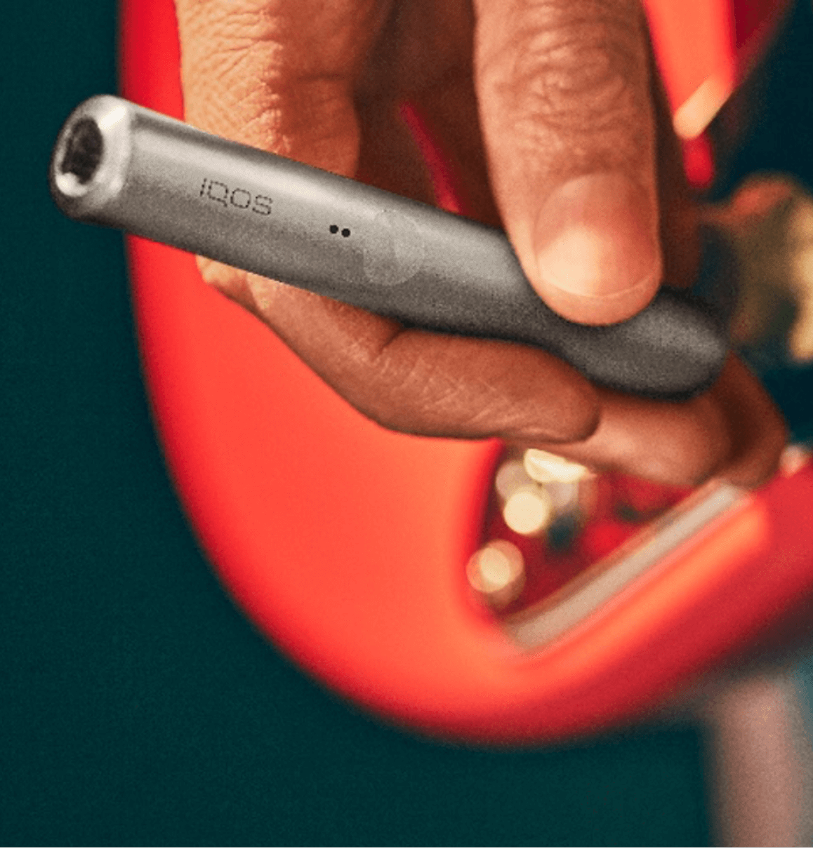 A silver IQOS with a red guitar.