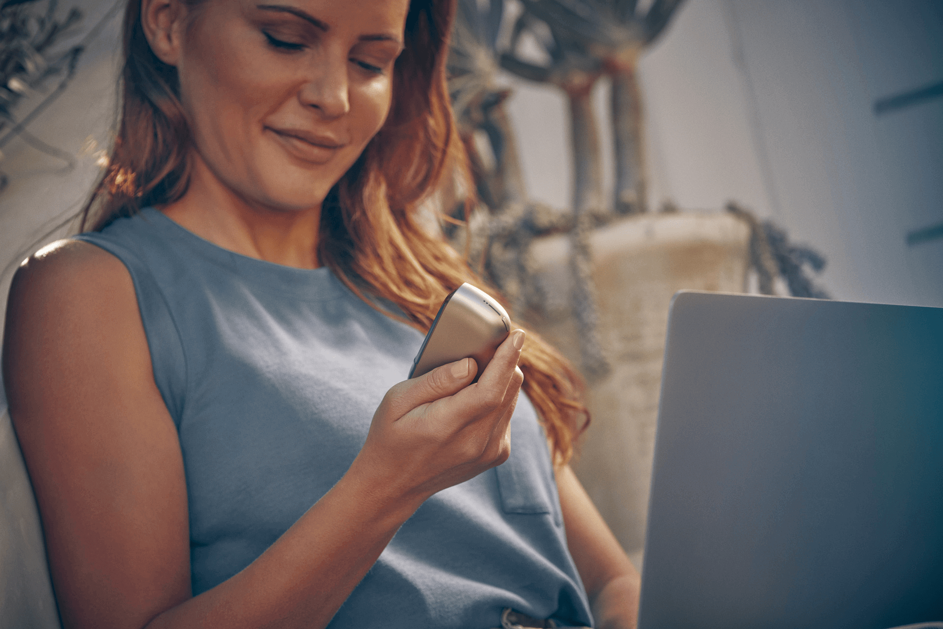 A woman looking at her IQOS device