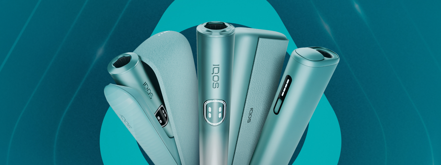 Um IQOS ILUMA PRIME, dois telemóveis com a App IQOS aberta e um portátil