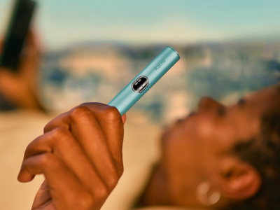 A woman looking at her IQOS device