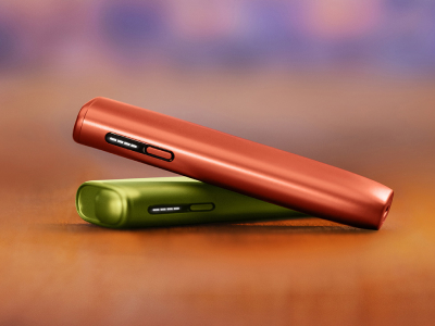 A woman looking at her IQOS device