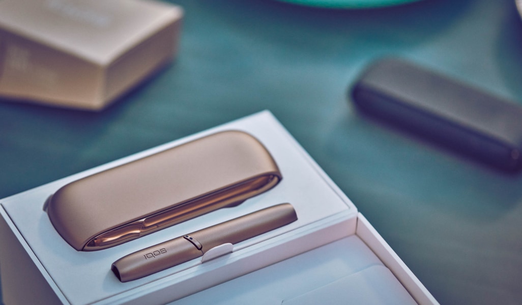 Girl with a flight ticket, an IQOS device, a passport and a luggage