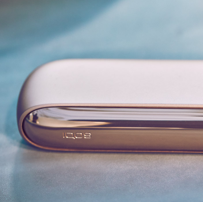 Brilliant gold IQOS 3 DUO holder and charger on a digital music production panel