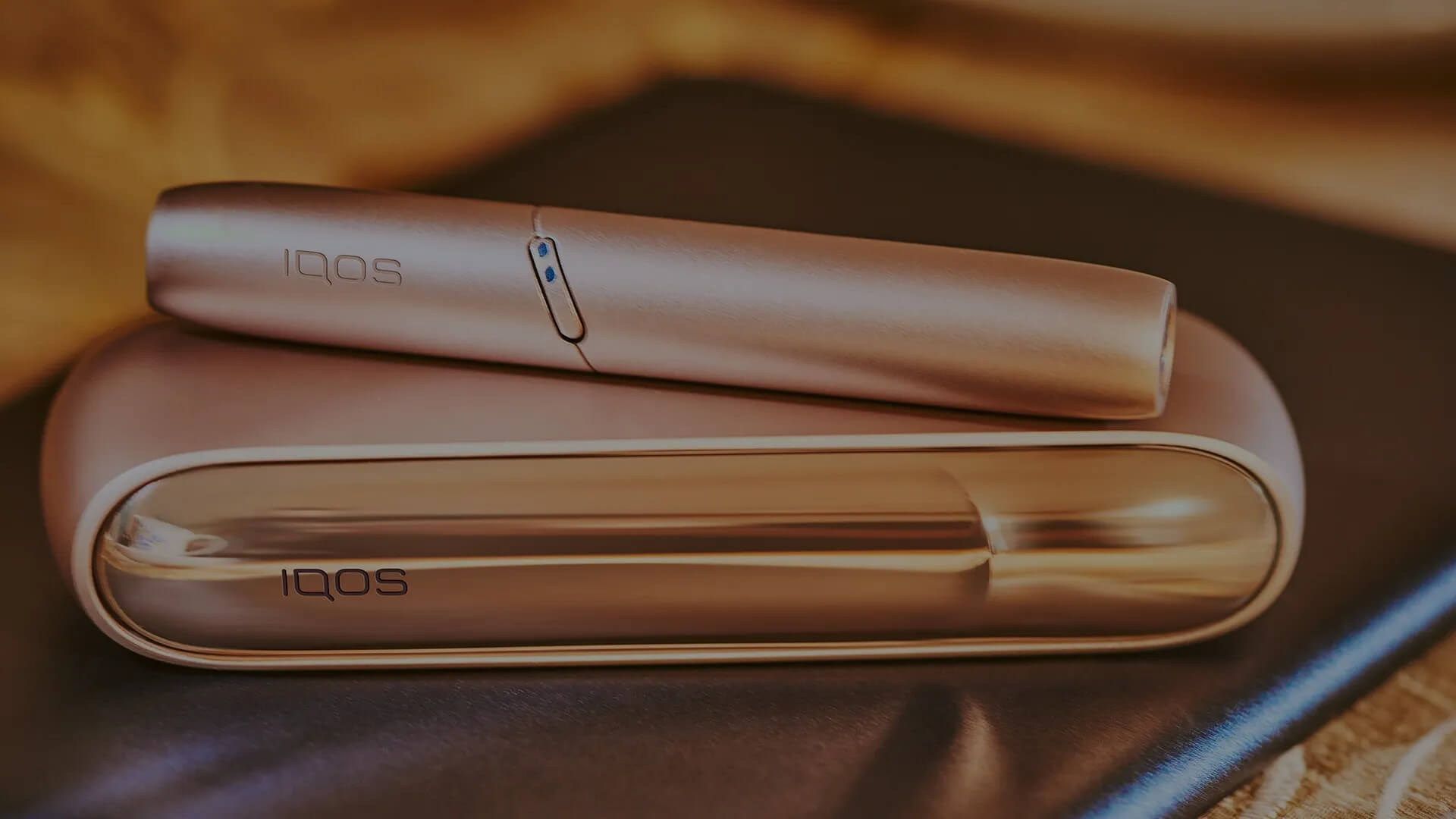 Gold IQOS Duo on a wooden table