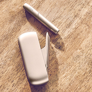 IQOS DUO on a table while two people are talking