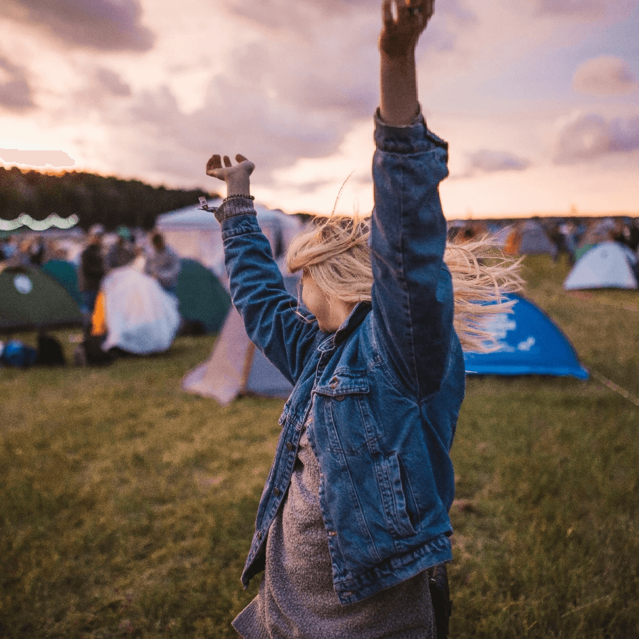 A woman dancing in a campsite.
