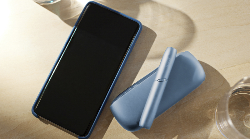 a phone and a turquoise IQOS original.