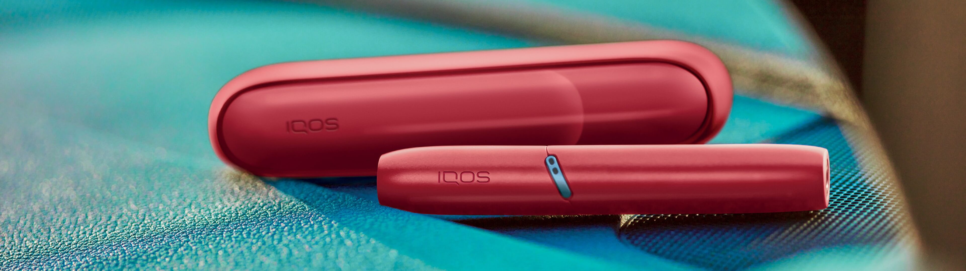 IQOS 3 DUO and charger laying on a chair