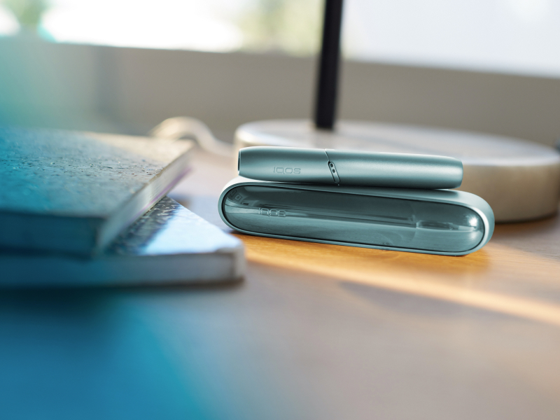 IQOS device on a desk beside some books