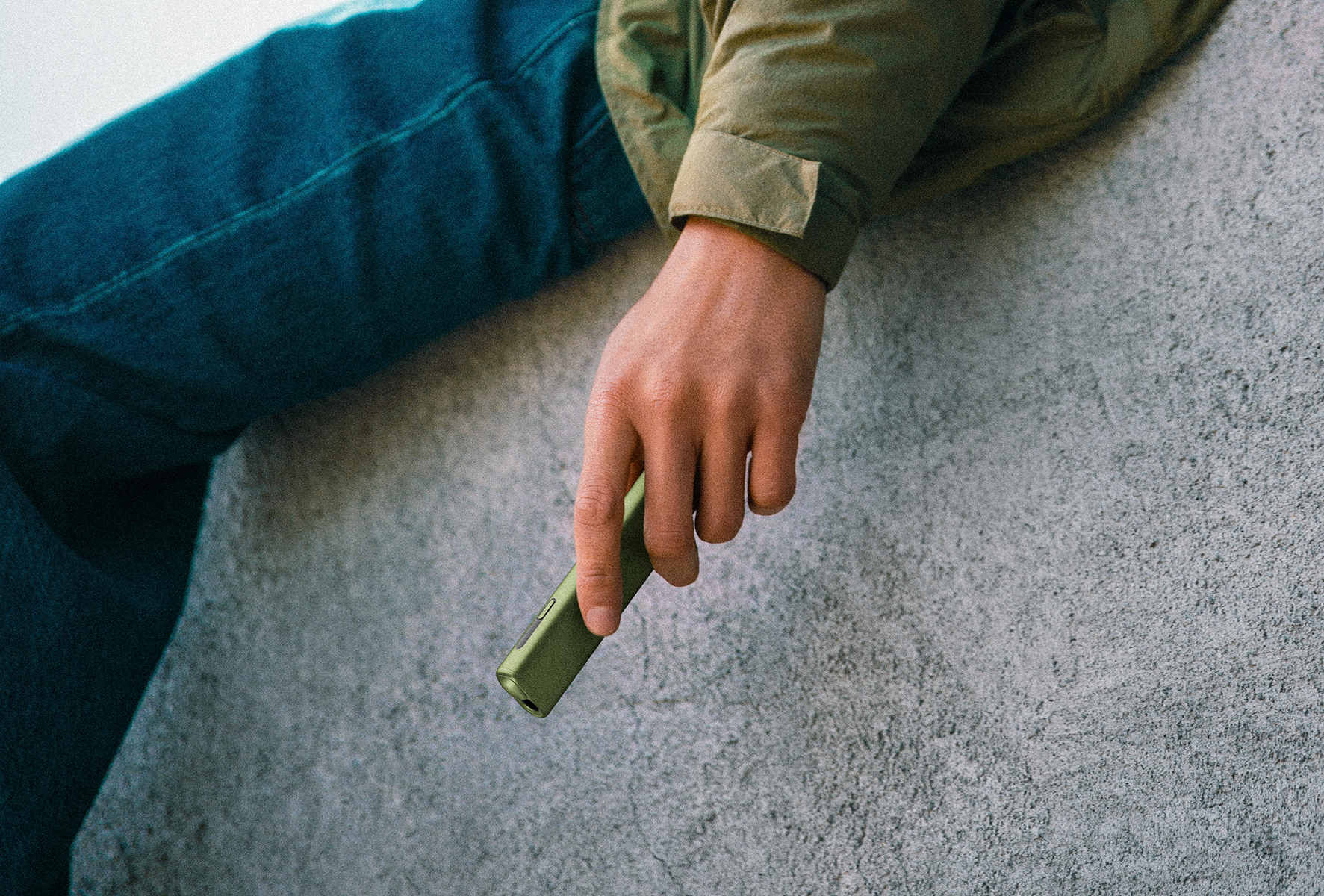 A woman with red nails holding an IQOS device